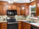 Traditional kitchen featuring hardwood cabinetry, tile backsplash, and modern appliances at 2698 E Cresthill Ave, Centennial, CO 80121
