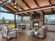 Inviting outdoor living space with a stone fireplace, wood ceiling, bar seating, and scenic views at 2698 E Cresthill Ave, Centennial, CO 80121