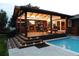 Inviting outdoor living space with a covered deck, fireplace, tv, and adjacent pool at 2698 E Cresthill Ave, Centennial, CO 80121