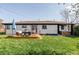 Spacious backyard with lush green grass, a cozy seating area on a wooden deck, and a relaxing hot tub at 11354 Allendale Dr, Arvada, CO 80004
