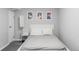 Clean, minimalist bedroom with white bed frame, gray linens, and modern artwork above the bed at 11354 Allendale Dr, Arvada, CO 80004