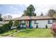 Charming home featuring a vibrant blue door, lush lawn, and inviting front porch with comfortable seating at 11354 Allendale Dr, Arvada, CO 80004