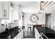 Bright kitchen features white cabinetry, stylish backsplash, and black countertops, creating a modern and inviting space at 11354 Allendale Dr, Arvada, CO 80004