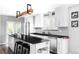 Modern kitchen boasting stainless steel appliances, white cabinets, black countertops, and a spacious island with seating at 11354 Allendale Dr, Arvada, CO 80004