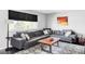 Bright living room features a comfortable gray sectional, rustic wood coffee table, and stylish patterned rug at 11354 Allendale Dr, Arvada, CO 80004