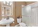 Bathroom featuring a pedestal sink and tiled shower at 931 Forest View Rd, Monument, CO 80132