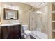 Bathroom features a wood vanity, toilet, and glass shower with tan tile at 931 Forest View Rd, Monument, CO 80132