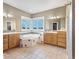 Spacious bathroom featuring dual vanities, a tub, and a tile floor at 931 Forest View Rd, Monument, CO 80132