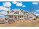 Beautiful two-story home featuring a spacious wrap-around porch, enhanced by a stone retaining wall and mature trees at 931 Forest View Rd, Monument, CO 80132
