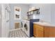 Laundry room with blue walls, stylish tile floors, a utility sink, shelving, and a washer and dryer at 931 Forest View Rd, Monument, CO 80132