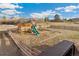 Outdoor fenced playground featuring a slide, swings, and a playhouse in a grassy yard at 931 Forest View Rd, Monument, CO 80132