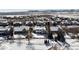 An aerial view shows a snow covered neighborhood with a frozen pond and mountain backdrop at 17853 W 77Th Ln, Arvada, CO 80007