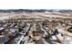 An aerial shot shows a snow covered neighborhood with a mountain backdrop and snow-covered roads at 17853 W 77Th Ln, Arvada, CO 80007