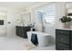 Modern bathroom featuring a soaker tub, double vanity, and plantation shutters at 17853 W 77Th Ln, Arvada, CO 80007