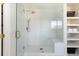 Modern shower features a glass door, built in bench and open shelving at 17853 W 77Th Ln, Arvada, CO 80007