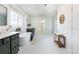Large primary bathroom featuring double vanities, soaker tub, and white tiled floors at 17853 W 77Th Ln, Arvada, CO 80007