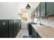 Laundry room featuring green cabinets, a utility sink, and modern appliances at 17853 W 77Th Ln, Arvada, CO 80007