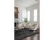 Bright living room featuring white armchairs, a stylish rug, and an abundance of natural light from shuttered windows at 17853 W 77Th Ln, Arvada, CO 80007