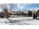 The rear exterior view of the home, featuring a partially frozen creek and light dusting of snow at 17853 W 77Th Ln, Arvada, CO 80007