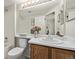 Bright bathroom with white countertop, wood cabinets, framed mirror, and shower at 7481 Singing Hills Dr, Boulder, CO 80301