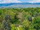 Scenic landscape view of a serene park, wooden bridge, lush greenery, and snow-capped mountains in the distance at 7481 Singing Hills Dr, Boulder, CO 80301