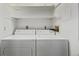 Laundry room featuring a white washer and dryer with overhead shelves at 7481 Singing Hills Dr, Boulder, CO 80301