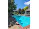 A refreshing community pool with lounge chairs and a building on the side, surrounded by mature trees at 7481 Singing Hills Dr, Boulder, CO 80301