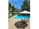 A sparkling community pool with an outdoor dining and lounge area, surrounded by lush greenery at 7481 Singing Hills Dr, Boulder, CO 80301