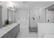 Bright bathroom featuring a glass-enclosed shower, soaking tub, and stylish tile flooring at 2385 S Marion St, Denver, CO 80210