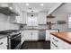 Bright kitchen with stainless steel appliances, white cabinets, dark countertops, and sleek subway tile backsplash at 2385 S Marion St, Denver, CO 80210