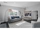 Comfortable living room featuring an elegant sofa, large windows, and a stylish coat rack at 2385 S Marion St, Denver, CO 80210