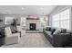 Cozy living room featuring a stone fireplace, large windows, and stylish, neutral-toned furniture and décor at 2385 S Marion St, Denver, CO 80210