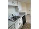 Close-up of the kitchen sink and countertop with white cabinets and black hardware at 942 S Walden St # 206, Aurora, CO 80017