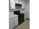 Corner of kitchen highlighting white cabinets, dark hardware, and a black stove at 942 S Walden St # 206, Aurora, CO 80017