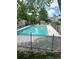 Community pool with clear blue water, lounge chairs, surrounded by mature trees and wrought iron fence at 942 S Walden St # 206, Aurora, CO 80017