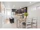 Open dining area and kitchen featuring stainless steel appliances, white countertops, and dark cabinets at 12777 Ulster St, Thornton, CO 80602