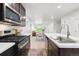 Modern kitchen featuring stainless steel appliances, white countertops, and dark cabinets at 12777 Ulster St, Thornton, CO 80602