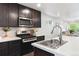 Modern kitchen featuring stainless steel appliances, white countertops, and dark cabinets at 12777 Ulster St, Thornton, CO 80602