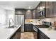 Modern kitchen featuring stainless steel appliances, white countertops, and dark cabinets at 12777 Ulster St, Thornton, CO 80602