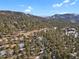 Home surrounded by trees with mountain views in background at 25220 Montane Dr, Golden, CO 80401