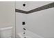 Clean bathroom with white tile, bathtub, and black accents at 25220 Montane Dr, Golden, CO 80401