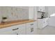 Laundry room with wood countertop and white cabinets at 25220 Montane Dr, Golden, CO 80401