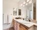 Well-lit bathroom with wood cabinets, tile countertop, and oval sink at 7755 E Quincy Ave # 301A7, Denver, CO 80237