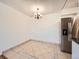 Bright dining space featuring chandelier lighting, tile flooring, and stainless steel refrigerator at 7755 E Quincy Ave # 301A7, Denver, CO 80237