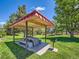 Outdoor gazebo with table, benches, and grill amidst a grassy area at 7755 E Quincy Ave # 301A7, Denver, CO 80237