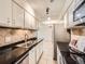 Modern kitchen featuring stainless steel appliances, tiled backsplash, and sleek black countertops at 7755 E Quincy Ave # 301A7, Denver, CO 80237