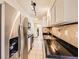 Galley kitchen with stainless steel refrigerator, black countertops, and white cabinets at 7755 E Quincy Ave # 301A7, Denver, CO 80237