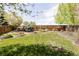 Expansive backyard featuring well-maintained lawn, mature trees, and decorative landscaping at 9469 W Ute Dr, Littleton, CO 80128