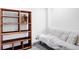 Basement with built-in shelving, great for storage or display, beside a neutral futon sleeper at 9469 W Ute Dr, Littleton, CO 80128