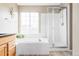 Bright bathroom featuring a bathtub, glass-enclosed shower, and modern fixtures, creating a spa-like retreat at 9469 W Ute Dr, Littleton, CO 80128